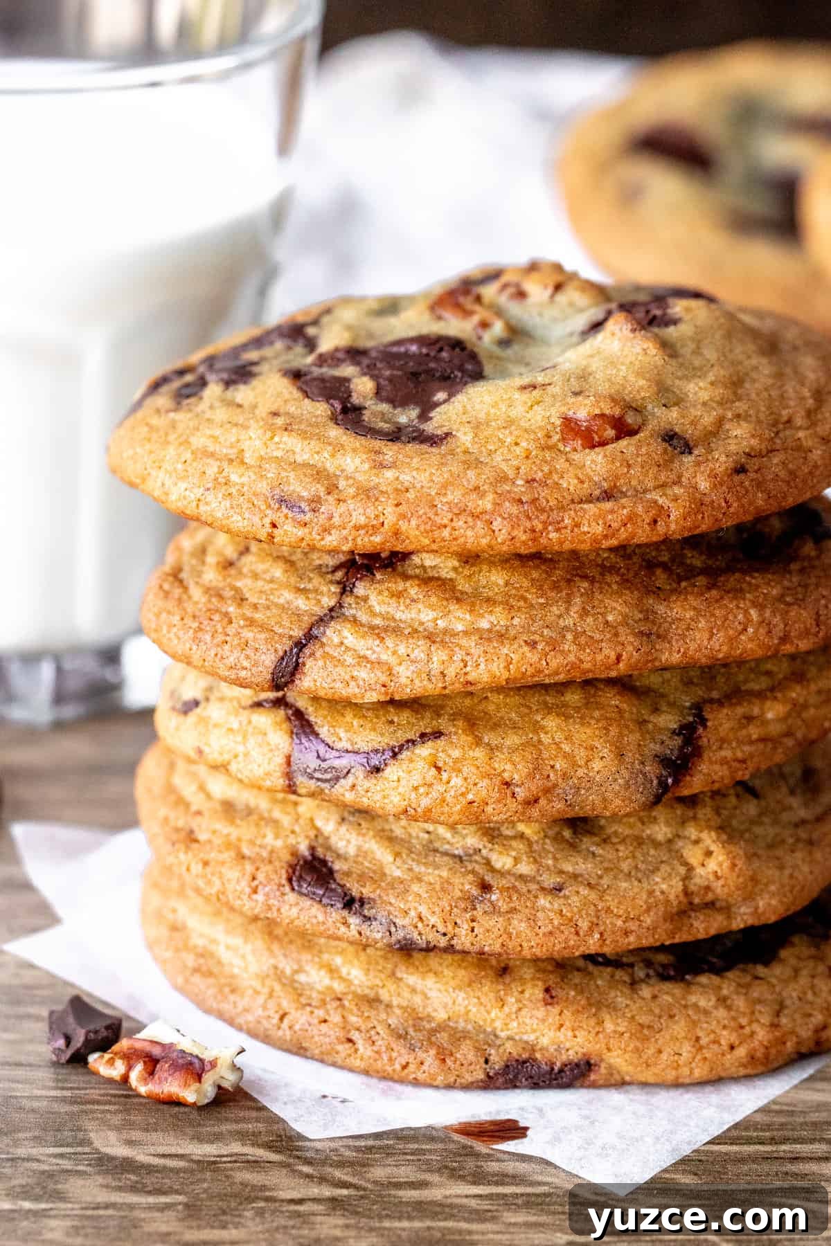 Brown Butter Pecan Chocolate Chip Cookies That Melt in Your Mouth 3 Pecan chocolate chip cookies stacked one on top of each other with a glass of milk