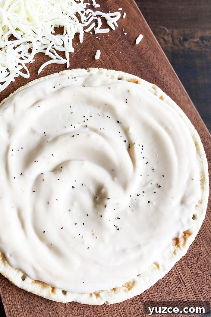 Creamy Garlic White Pizza Sauce Made in One Pot 3 Homemade White Pizza Sauce Spread on Pizza Dough