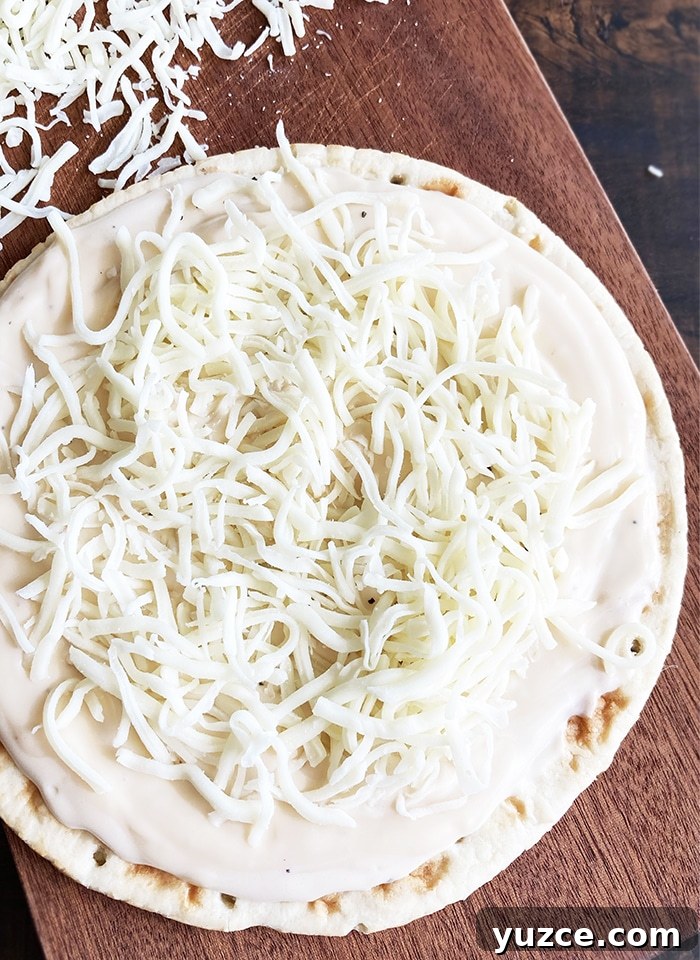 Creamy Garlic White Pizza Sauce Made in One Pot 4 White Cheese Sauce Spread on Pizza Dough, Topped off with Shredded Cheese