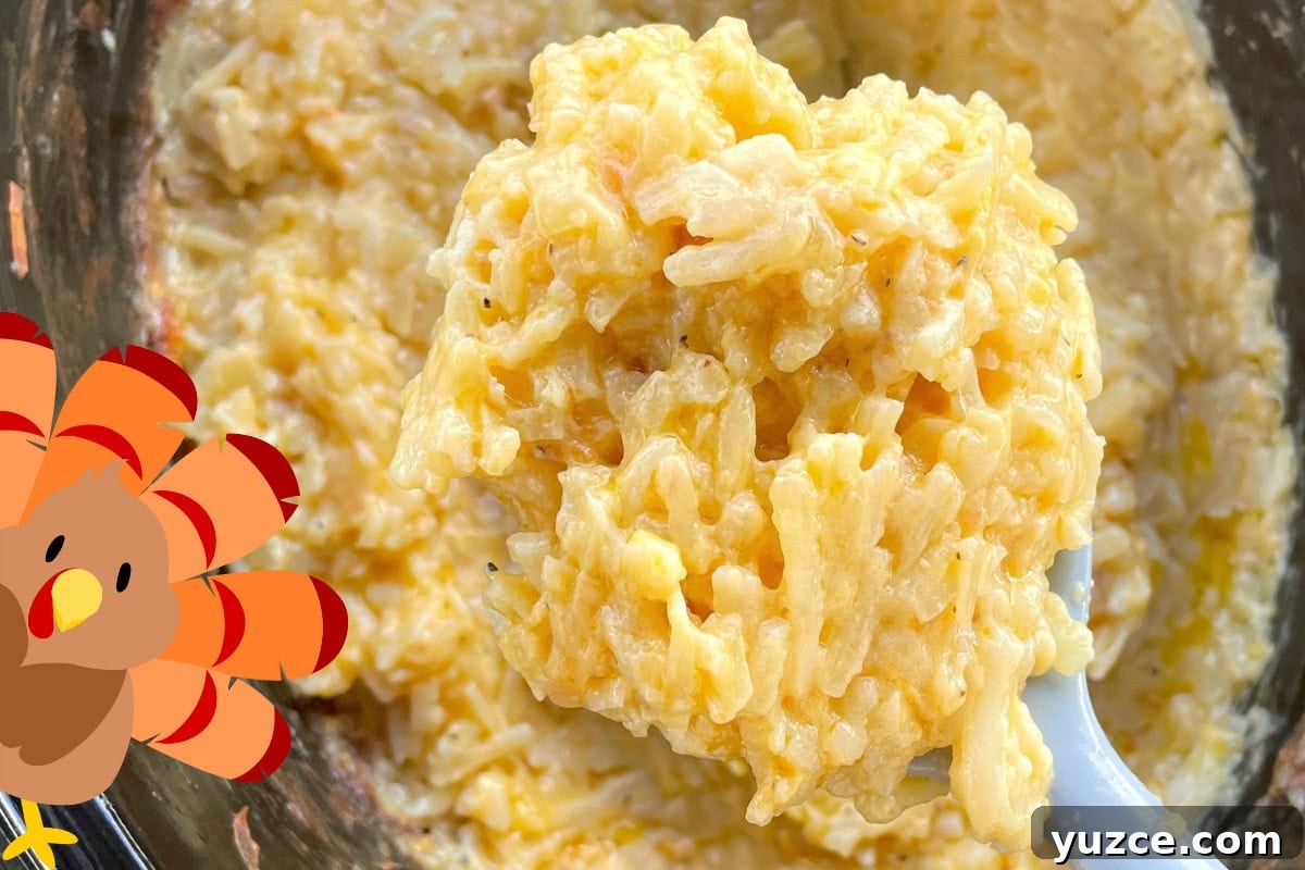 13 Crockpot Thanksgiving Recipes to Save Oven Space 6 Close-up view of a spoonful of hashbrowns and cheese with melted cheddar.
