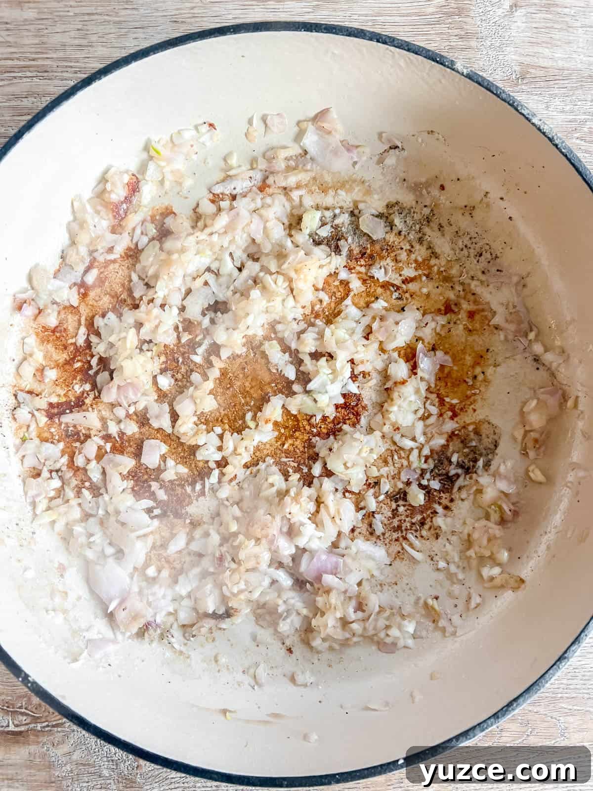 Dutch Oven Pork Tenderloin with Apples, Figs & Balsamic Glaze 5 Shallots and garlic in a dutch oven.