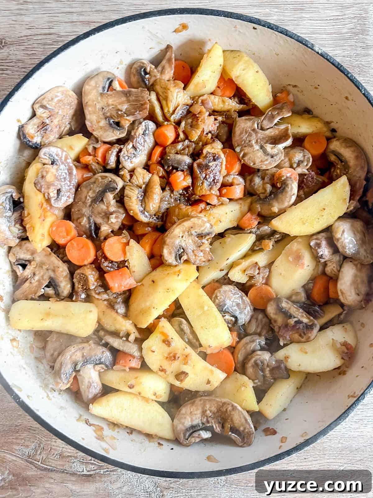 Dutch Oven Pork Tenderloin with Apples, Figs & Balsamic Glaze 6 Apples, carrots, mushrooms, and figs added to a dutch oven.
