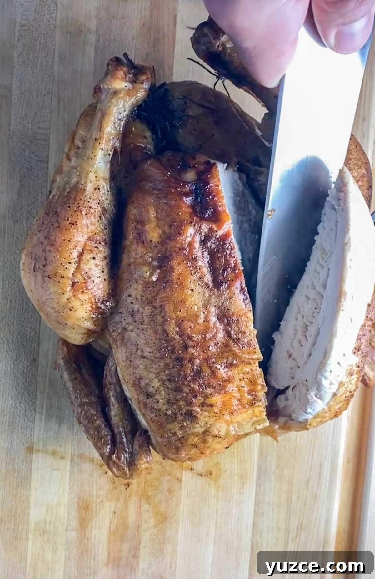Perfectly Roasted Whole Chicken in a Cast Iron Skillet 6 Cutting into a whole chicken breast with a chefs knife.