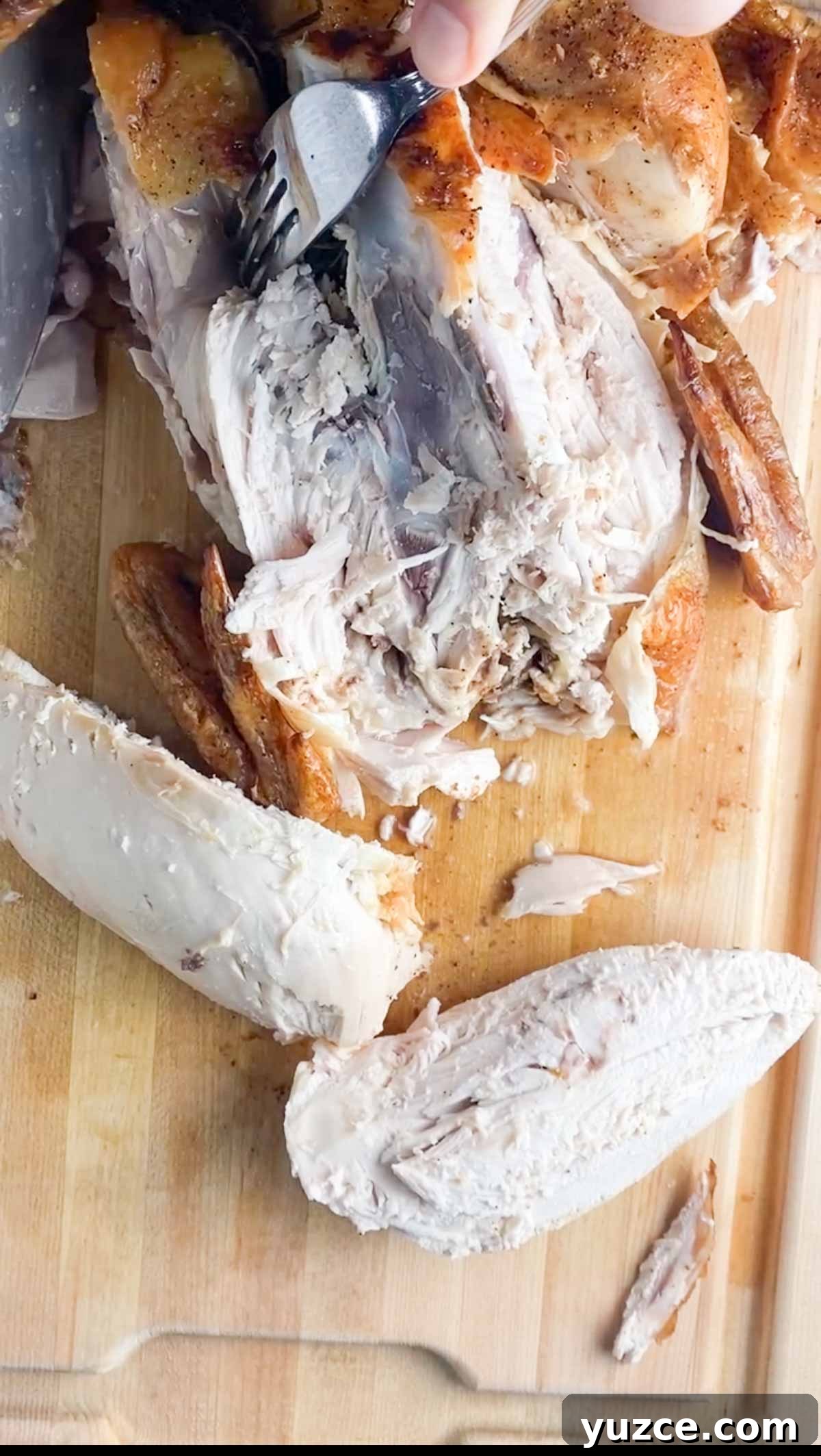 Perfectly Roasted Whole Chicken in a Cast Iron Skillet 7 Cutting off chicken legs from a whole chicken.