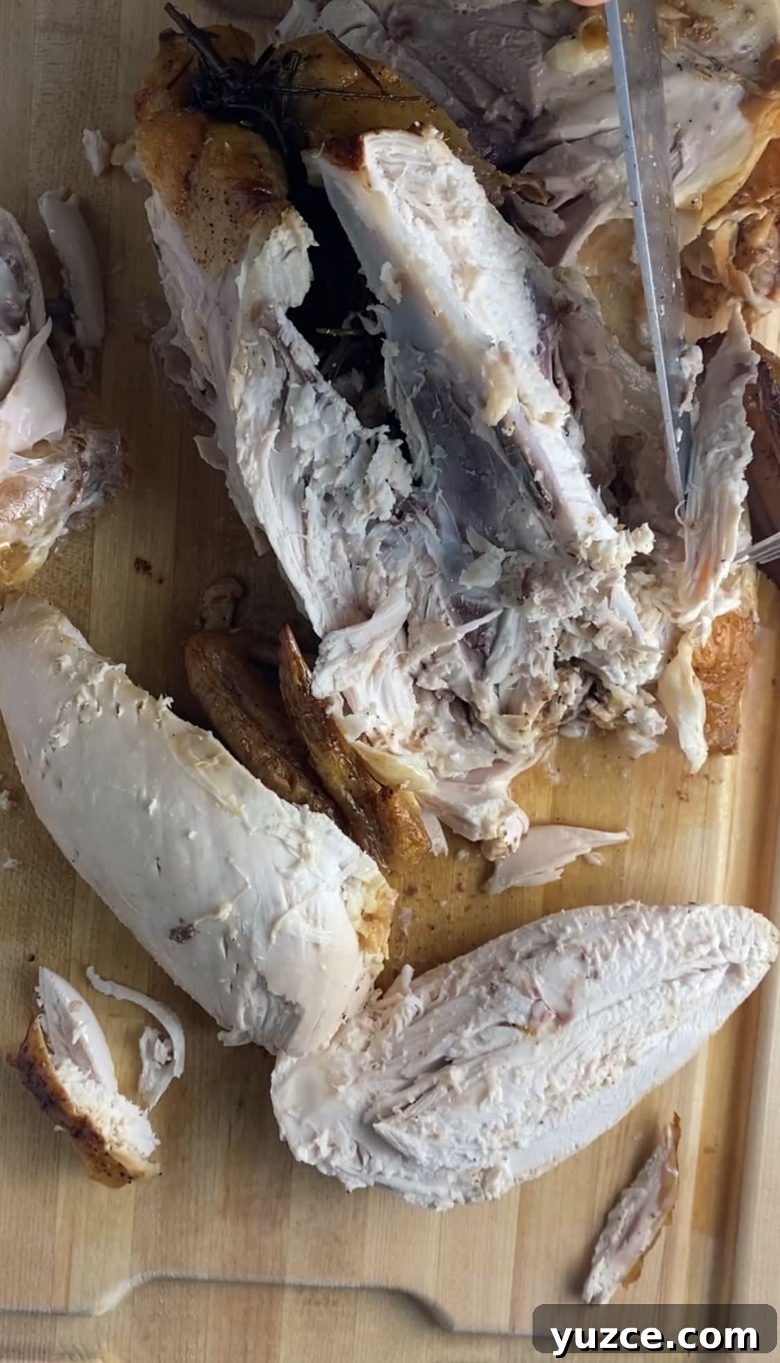 Perfectly Roasted Whole Chicken in a Cast Iron Skillet 8 Slicing the chicken breast from a whole chicken.
