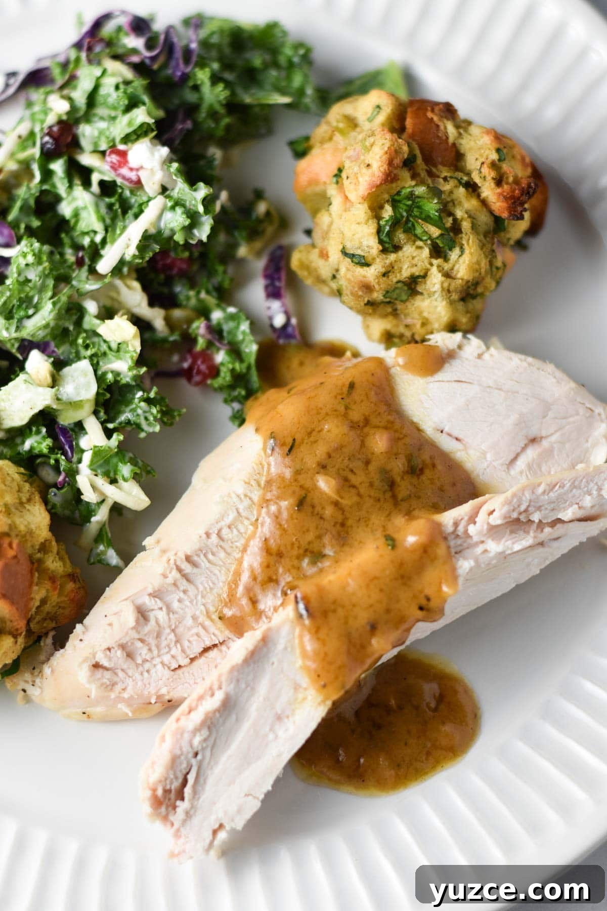 Perfectly Roasted Whole Chicken in a Cast Iron Skillet 10 Chicken with gravy next to kale salad and stuffing balls.