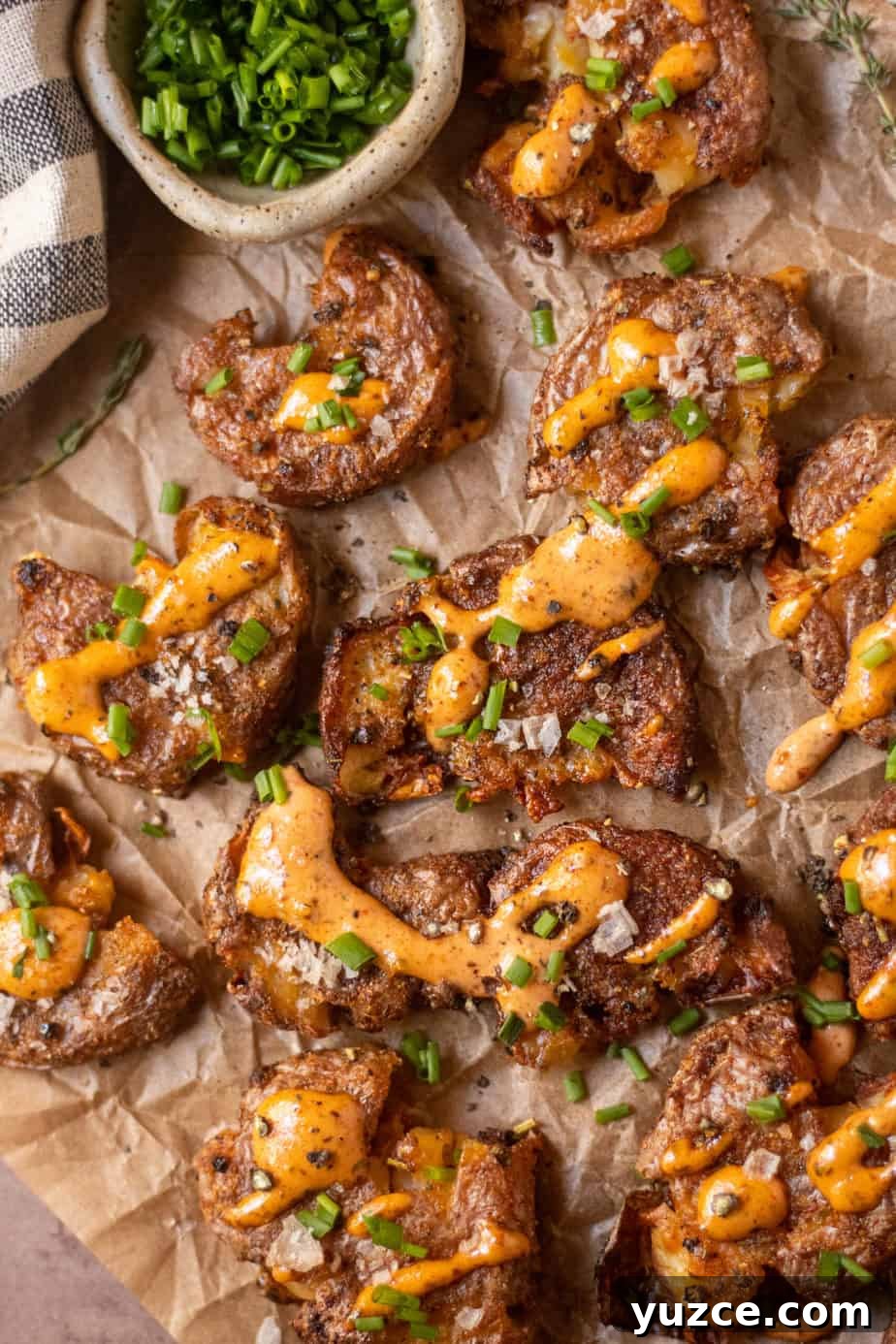 Crispy Smashed Potatoes with Spicy Creole Sauce 12 overhead shot of crispy smashed potatoes with creole sauce on parchment paper.