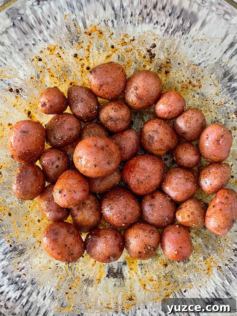 Crispy Smashed Potatoes with Spicy Creole Sauce 5 overgead shot of baby red potatoes coated in oil and spices