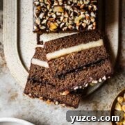 Traditional Polish Piernik Gingerbread Cake Recipe 11 Two slices of filled gingerbread cake on a tan platter.
