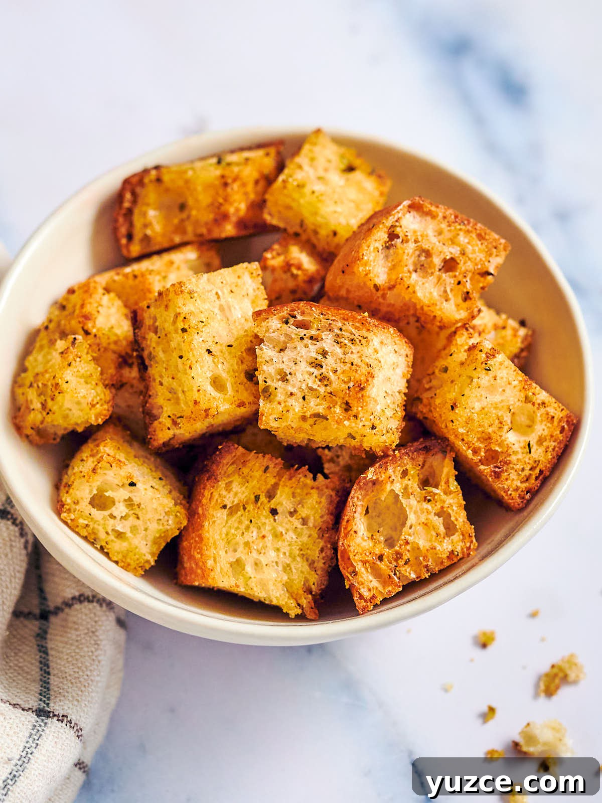 Crispy Air Fryer Crouton Recipe for Salad and Soup 2 Crispy air fryer croutons in a bowl on a marble counter.