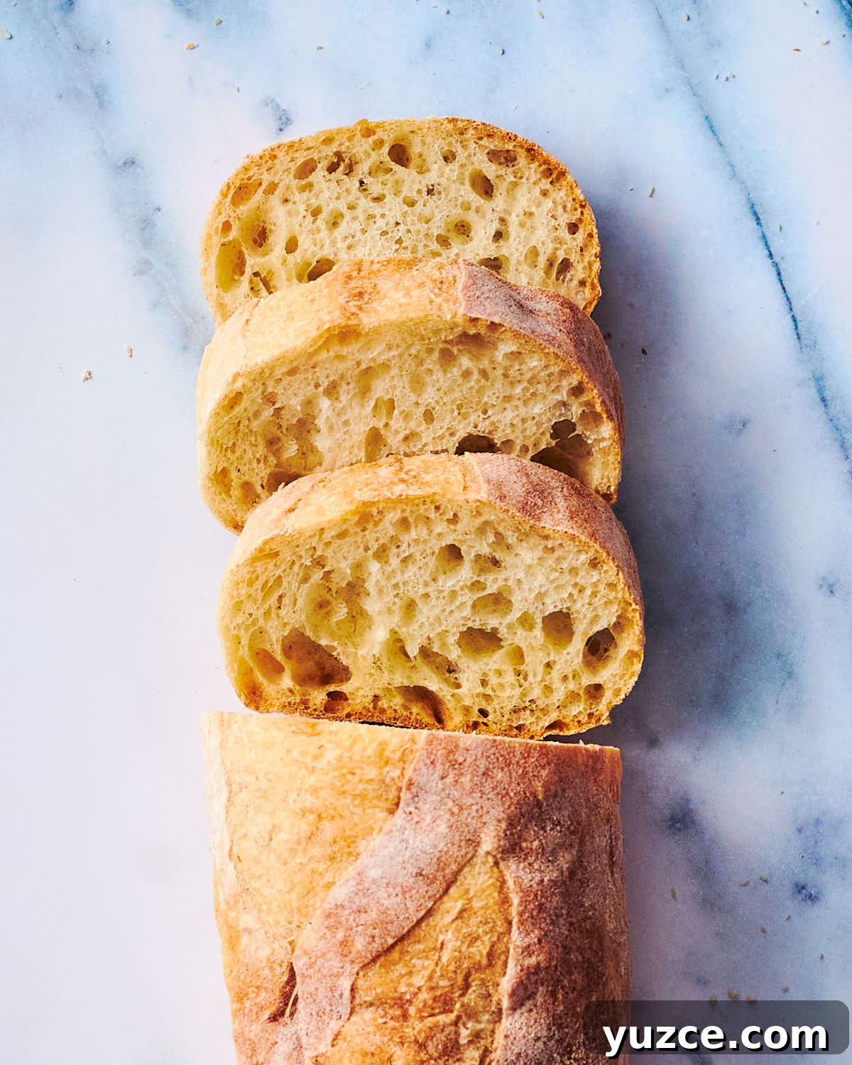 Crispy Air Fryer Crouton Recipe for Salad and Soup 14 Slices of baguette bread on marble counter.