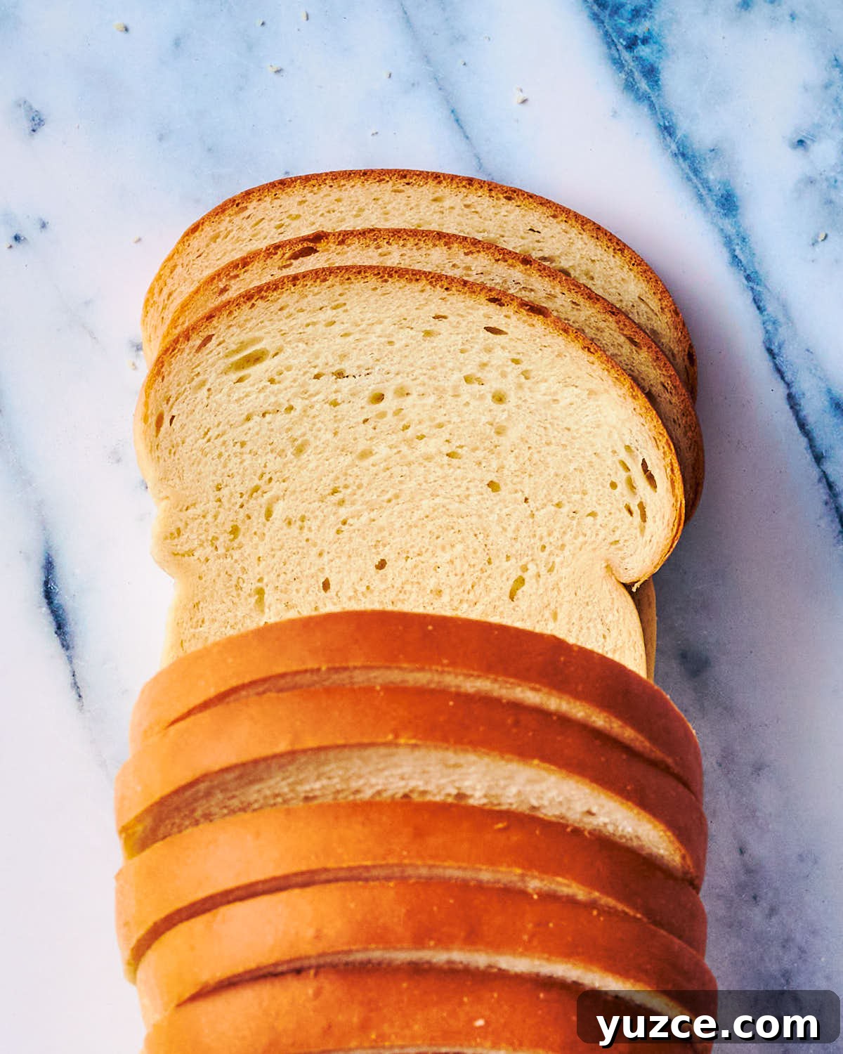 Crispy Air Fryer Crouton Recipe for Salad and Soup 16 Slices of white sandwich bread on a marble counter.