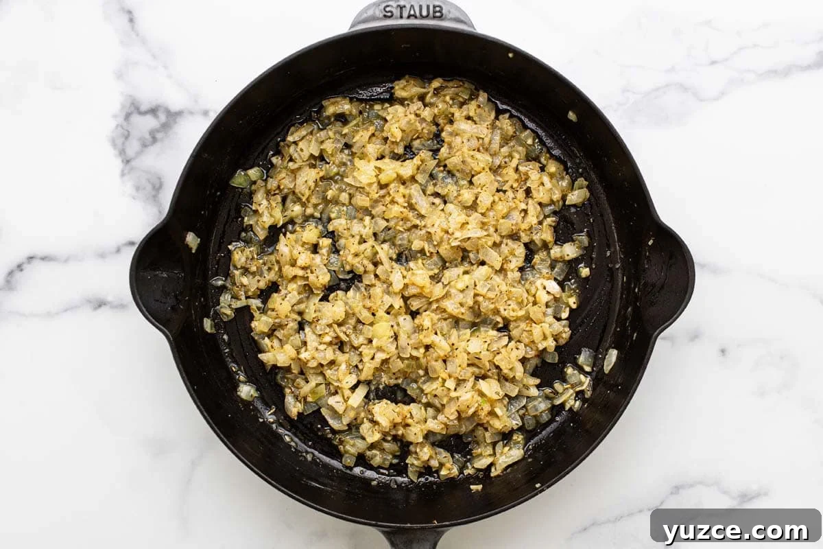 Large pan filled with sauteed onion and garlic. 