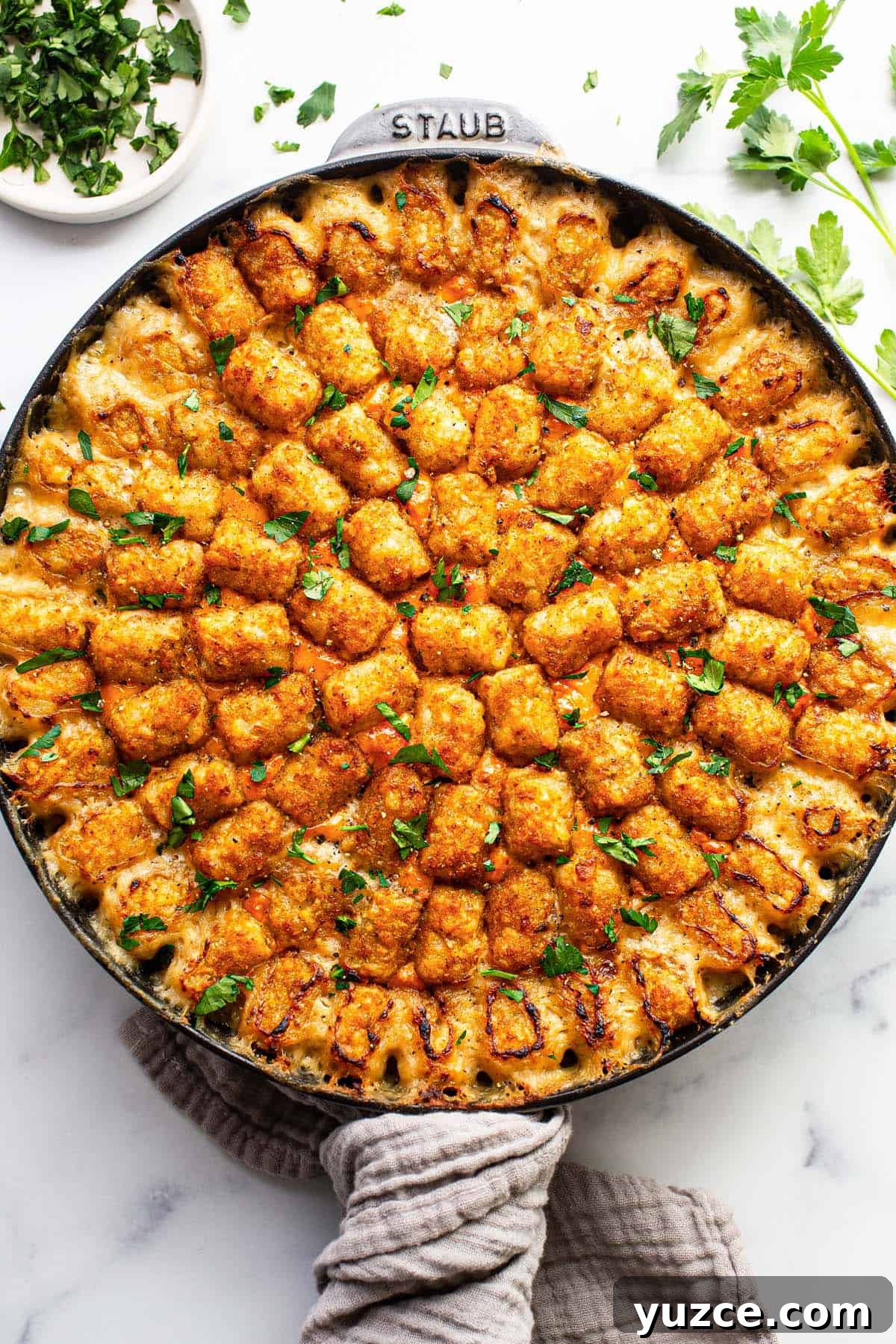 Large cast iron skillet with homemade chicken tater tot casserole. 