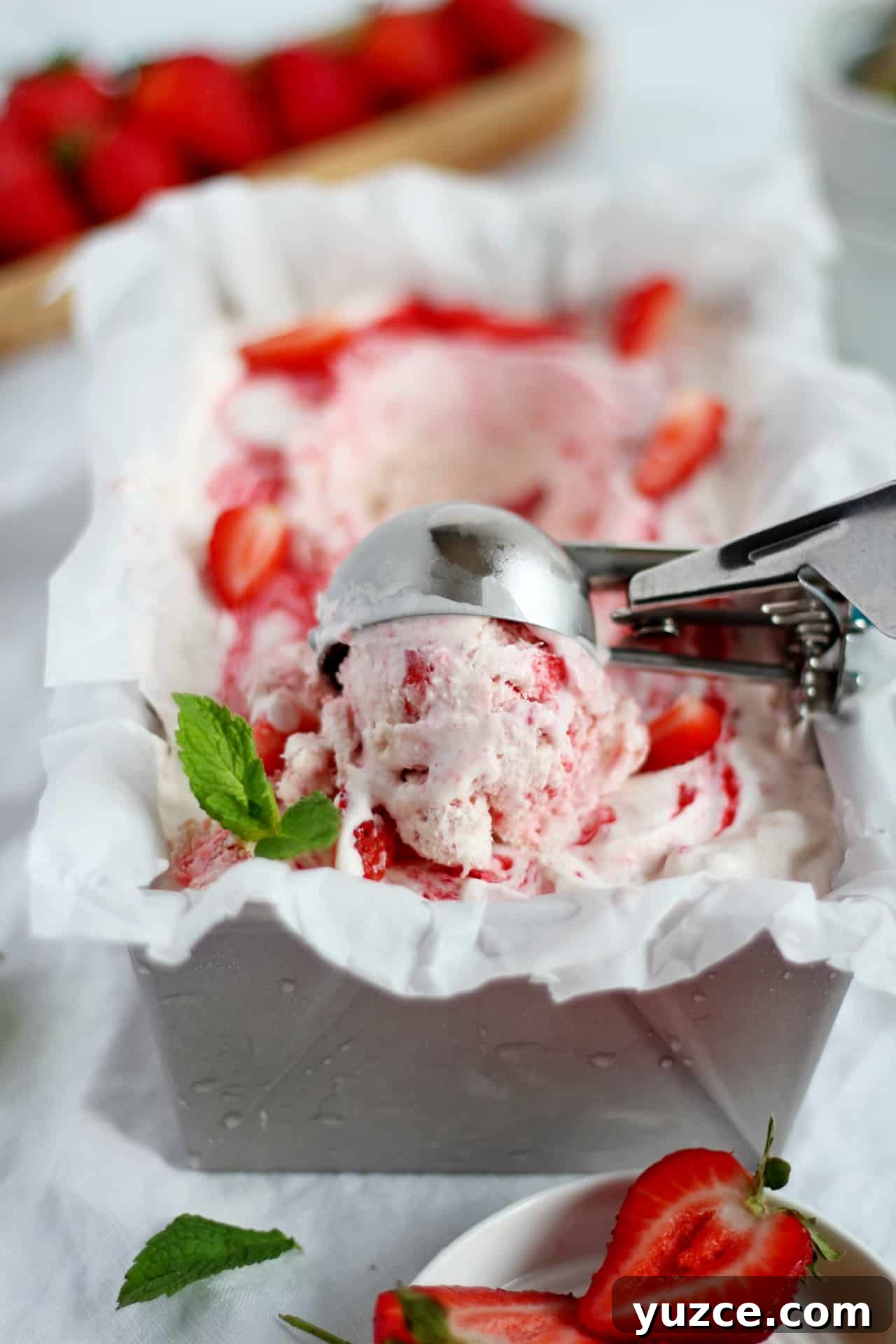 No-Churn Fresh Strawberry Ice Cream Recipe 3 scooping strawberry ice cream from loaf pan