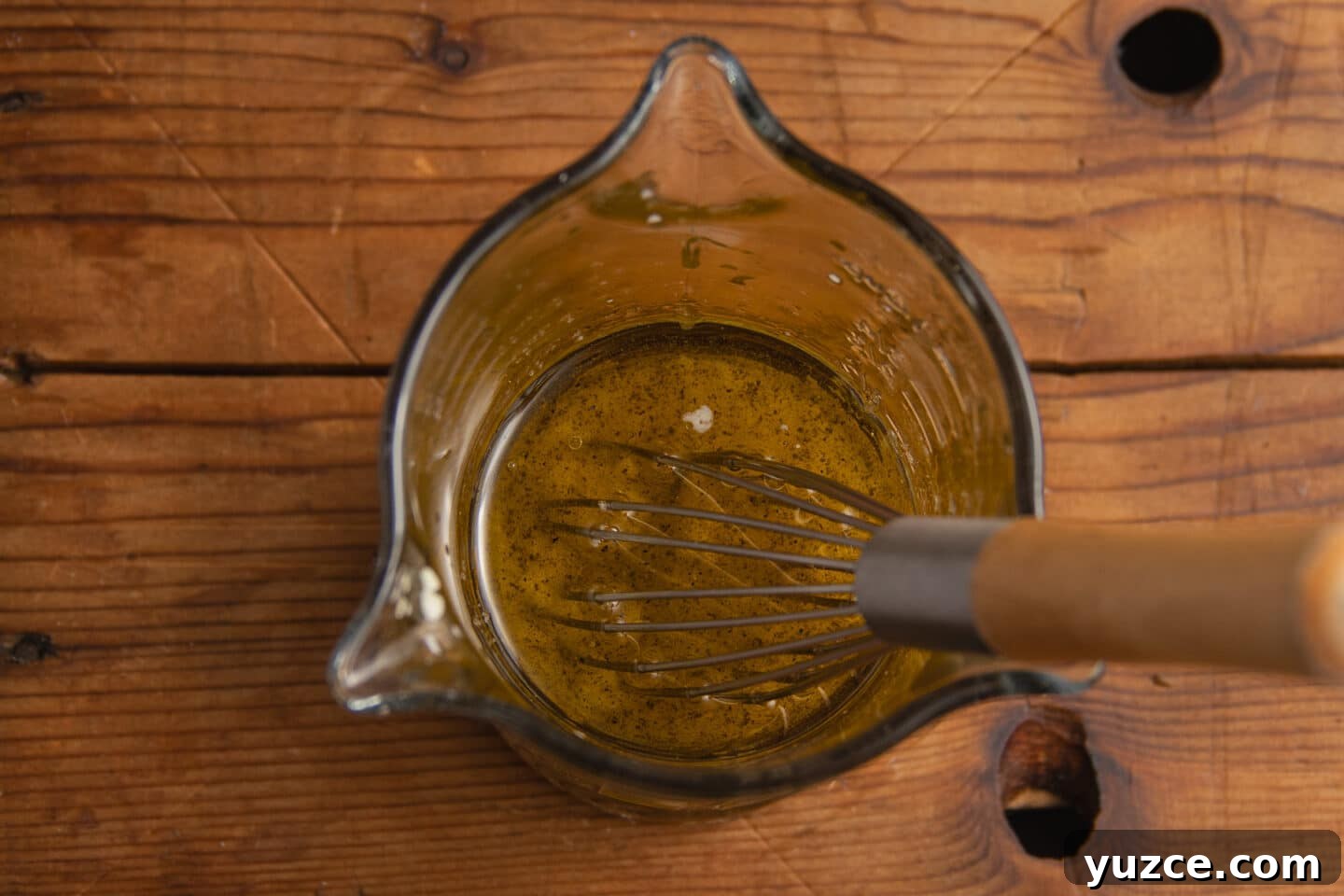 This is a picture of a cup with the salad dressing ingredients.