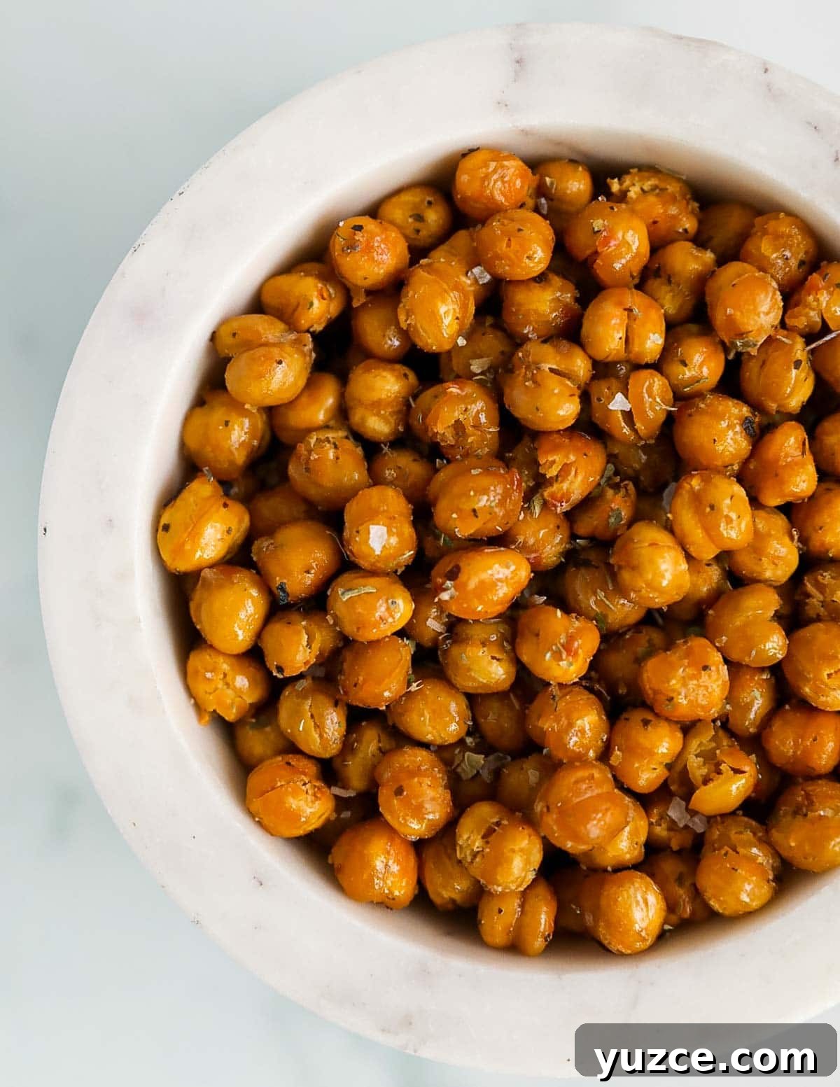A close up image of roasted chickpeas in a white bowl