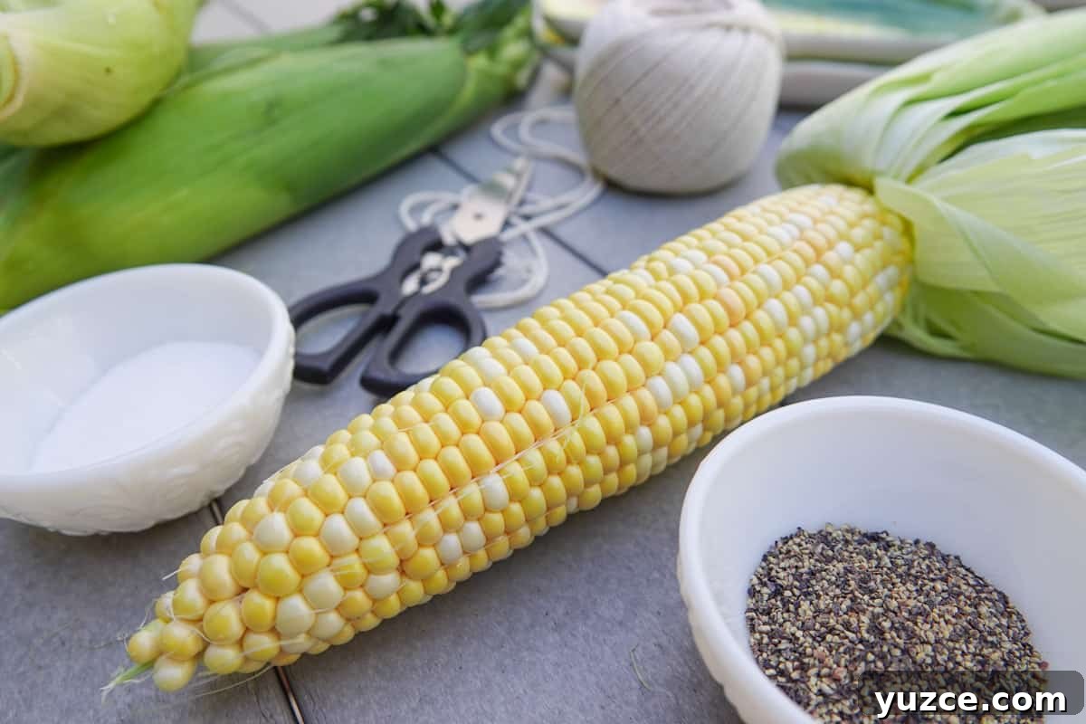 Smoky Butter-Grilled Corn on the Cob: Juicy Summer Side Recipe 2 Ear of corn on table with salt and pepper