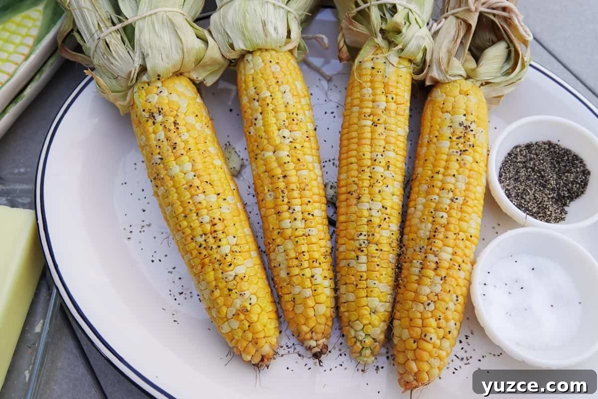 Smoky Butter-Grilled Corn on the Cob: Juicy Summer Side Recipe 10 smoked corn seasoned with salt and pepper on white plate