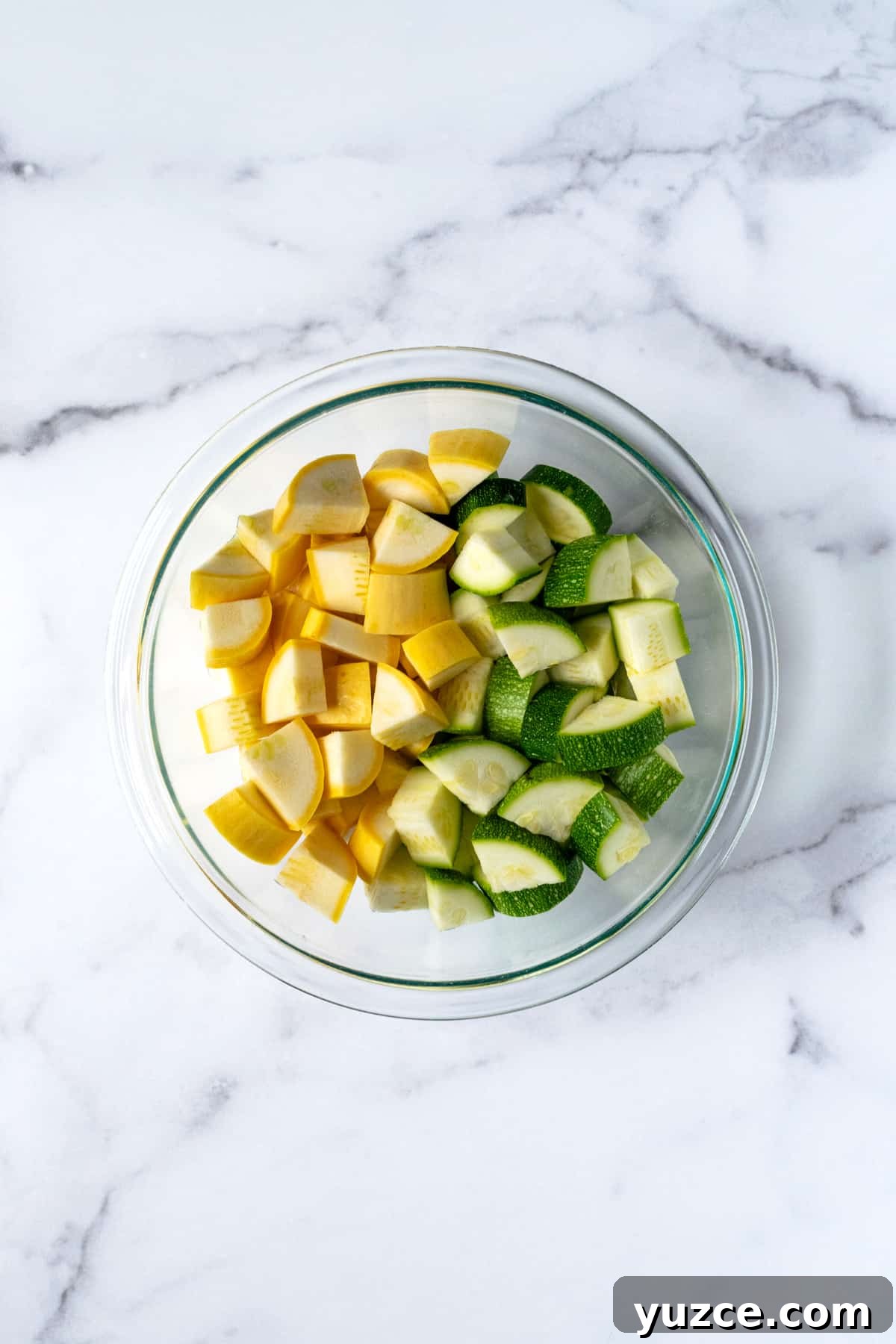 Crispy Air Fryer Zucchini & Summer Squash Recipe 4 Chopped Squash and Zucchini in a glass bowl.