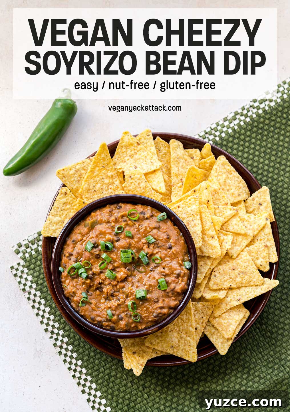 Pepperjack shreds, seasoned soyrizo and jalapeño peppers kick this Cheezy Soyrizo Bean Dip up a few notches! It a perfectly addictive appetizer. Bowl of soyrizo bean dip on a plate with chips, over a green placemat