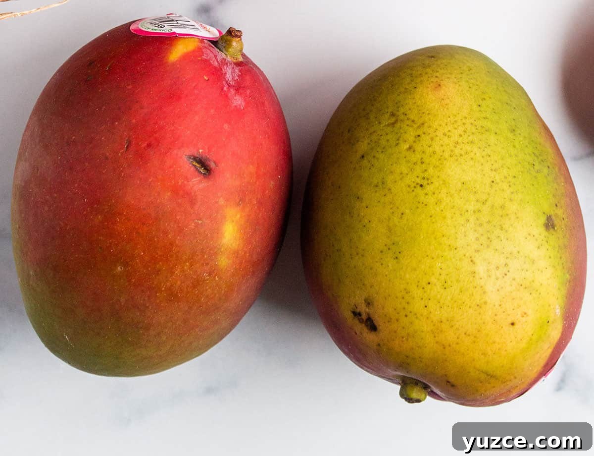 A pair of mangos, a red side and a green side.