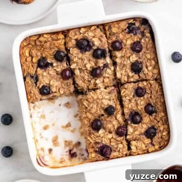 Vegan Baked Oatmeal Recipe with Fruit and Nuts 12 Baking dish with vegan baked oatmeal cut into squares, with one piece missing.