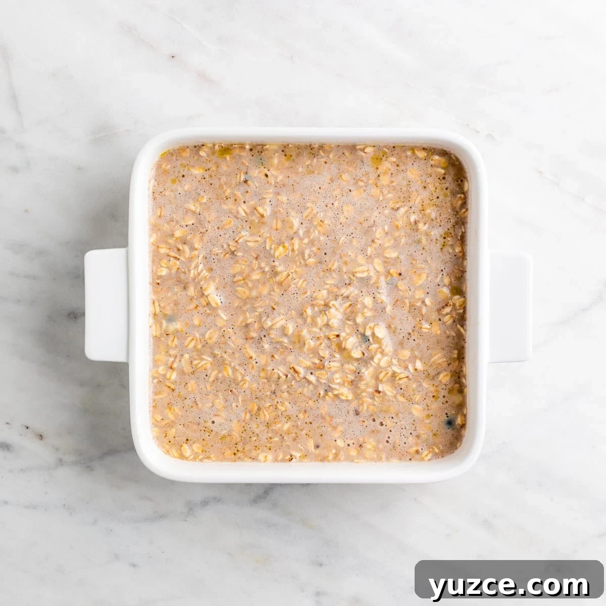 Vegan Baked Oatmeal Recipe with Fruit and Nuts 6 Vegan baked oatmeal mixture transferred to a baking dish.