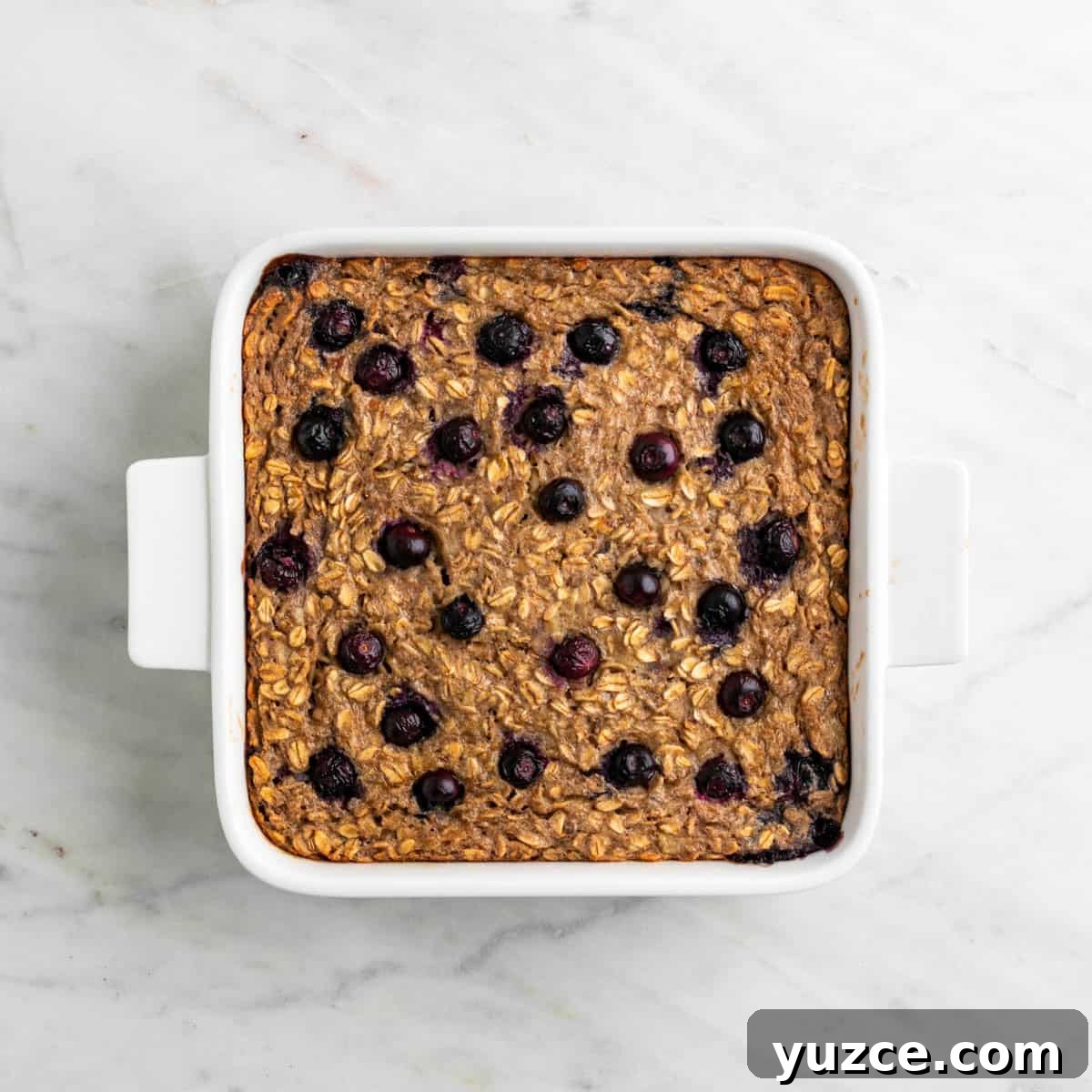 Vegan Baked Oatmeal Recipe with Fruit and Nuts 8 Vegan baked oatmeal baked in a baking dish.