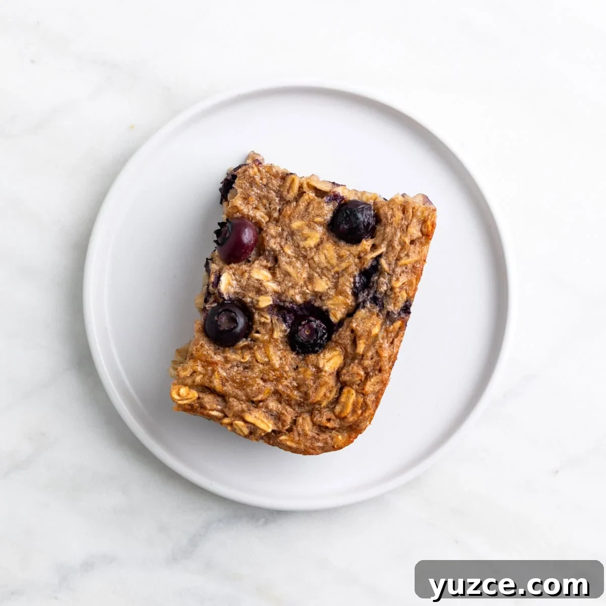 Vegan Baked Oatmeal Recipe with Fruit and Nuts 9 Slice of vegan baked oatmeal served on a plate.