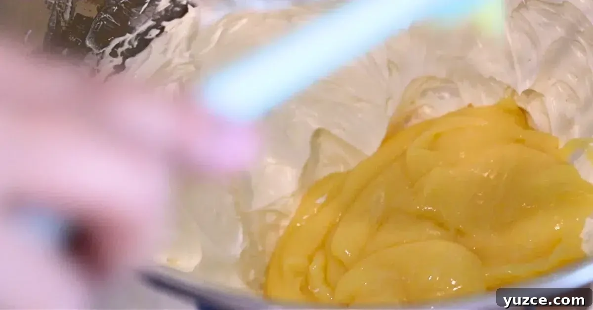 Luscious Lemon Buttercream Frosting Recipe for Cakes and Cupcakes 9 adding lemon curd to Swiss buttercream