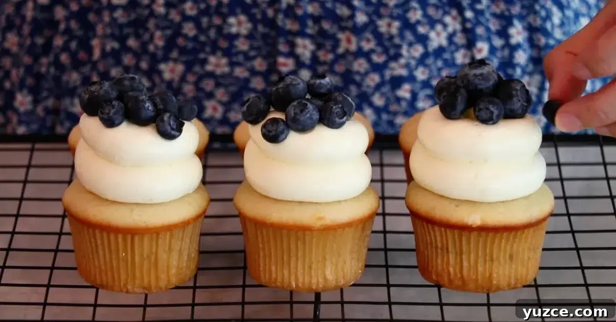 Luscious Lemon Buttercream Frosting Recipe for Cakes and Cupcakes 5 lemon cupcakes with lemon buttercream frosting and fresh blueberries on top