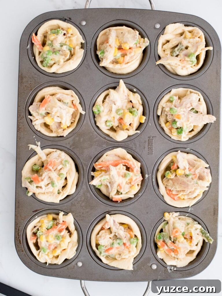 Mini Chicken Pot Pies Baked in Crescent Rolls 8 unbaked chicken pot pie bites in a muffin tin
