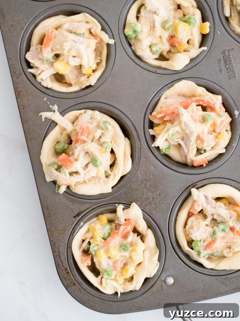 Mini Chicken Pot Pies Baked in Crescent Rolls 9 chicken pot pie bites in a muffin tin unbaked