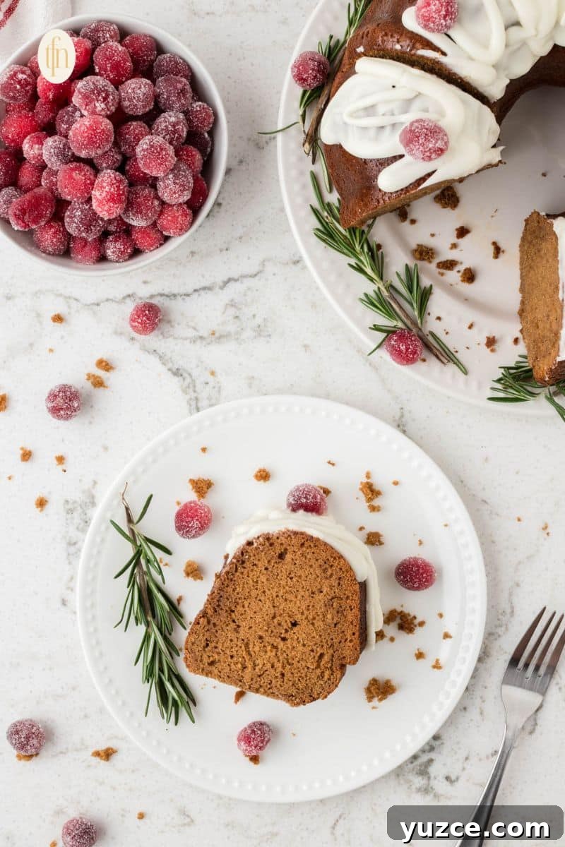 Slice of cake on a white plate with a bowl of red balls and a plate of bundt cake.