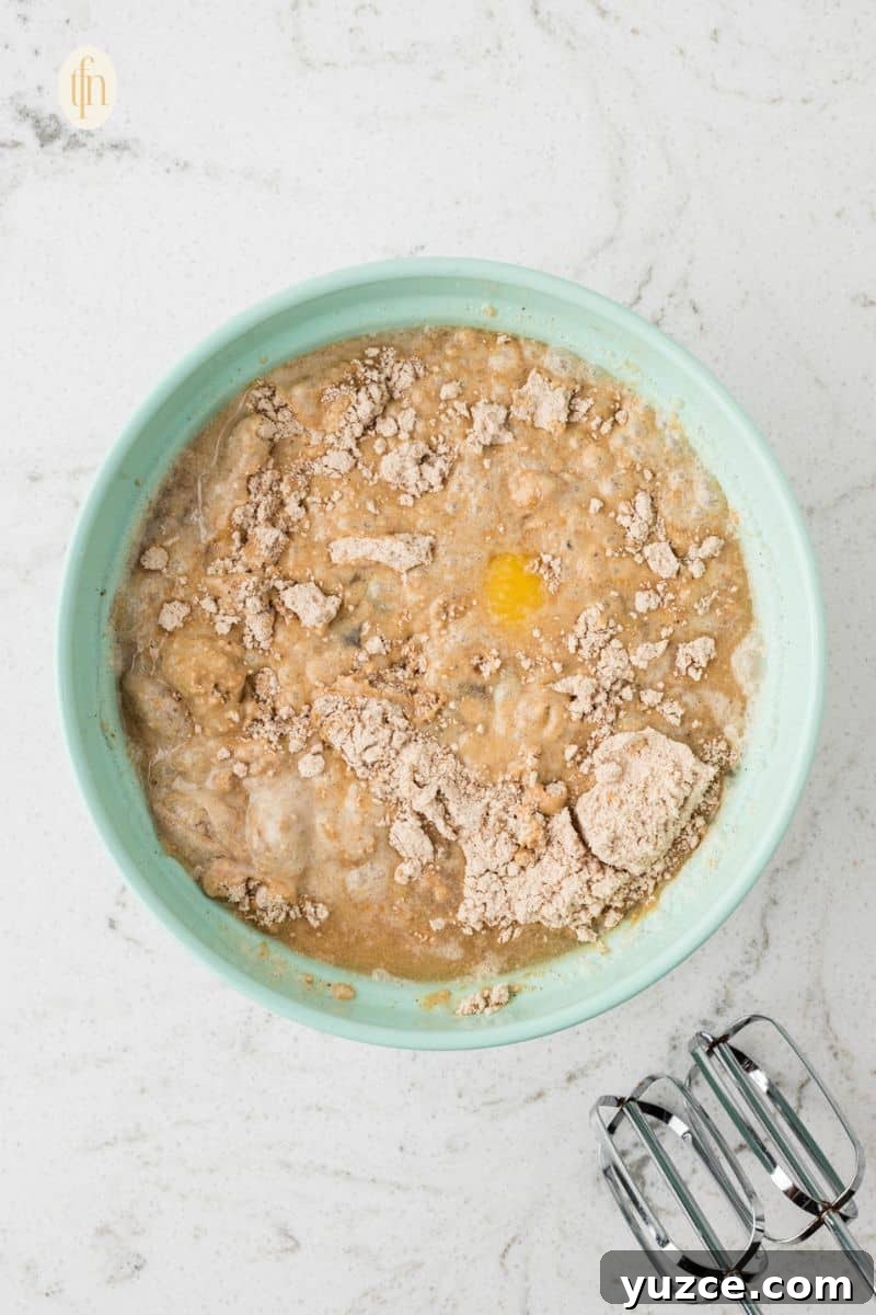 Mixed ingredients of cake recipe in a green bowl.