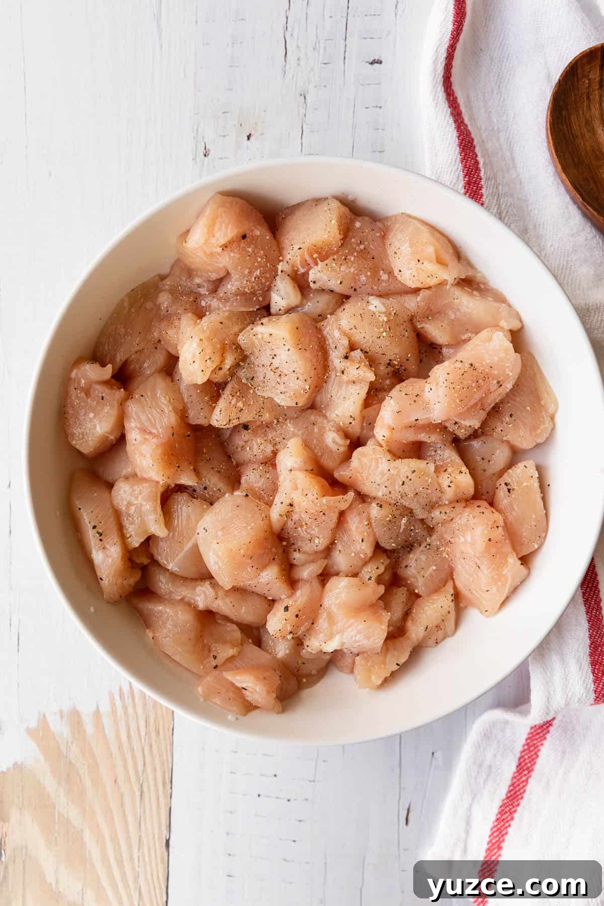 a bowl of raw chicken breast cut into small pieces