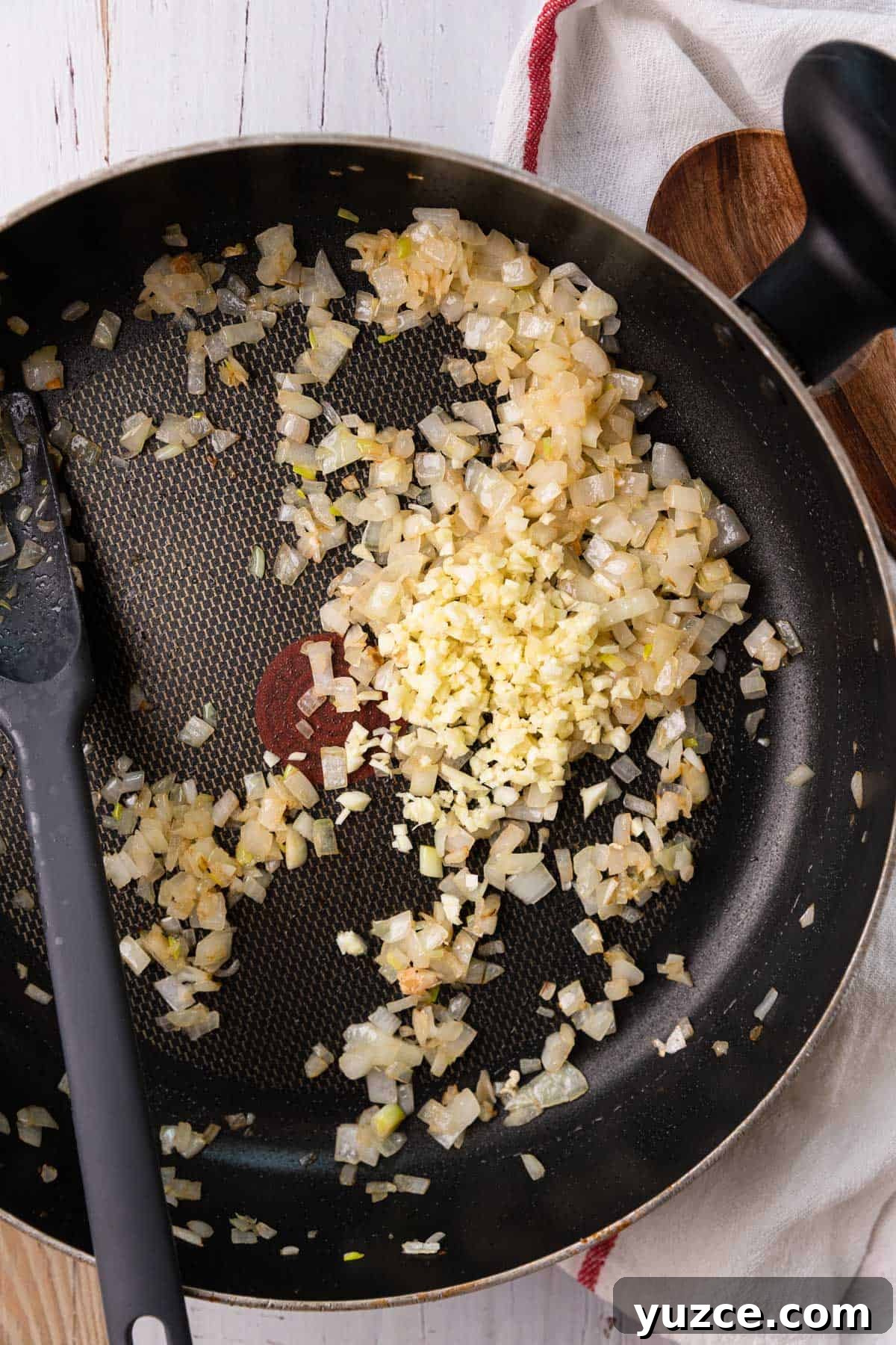a skillet with onions and garlic cooking