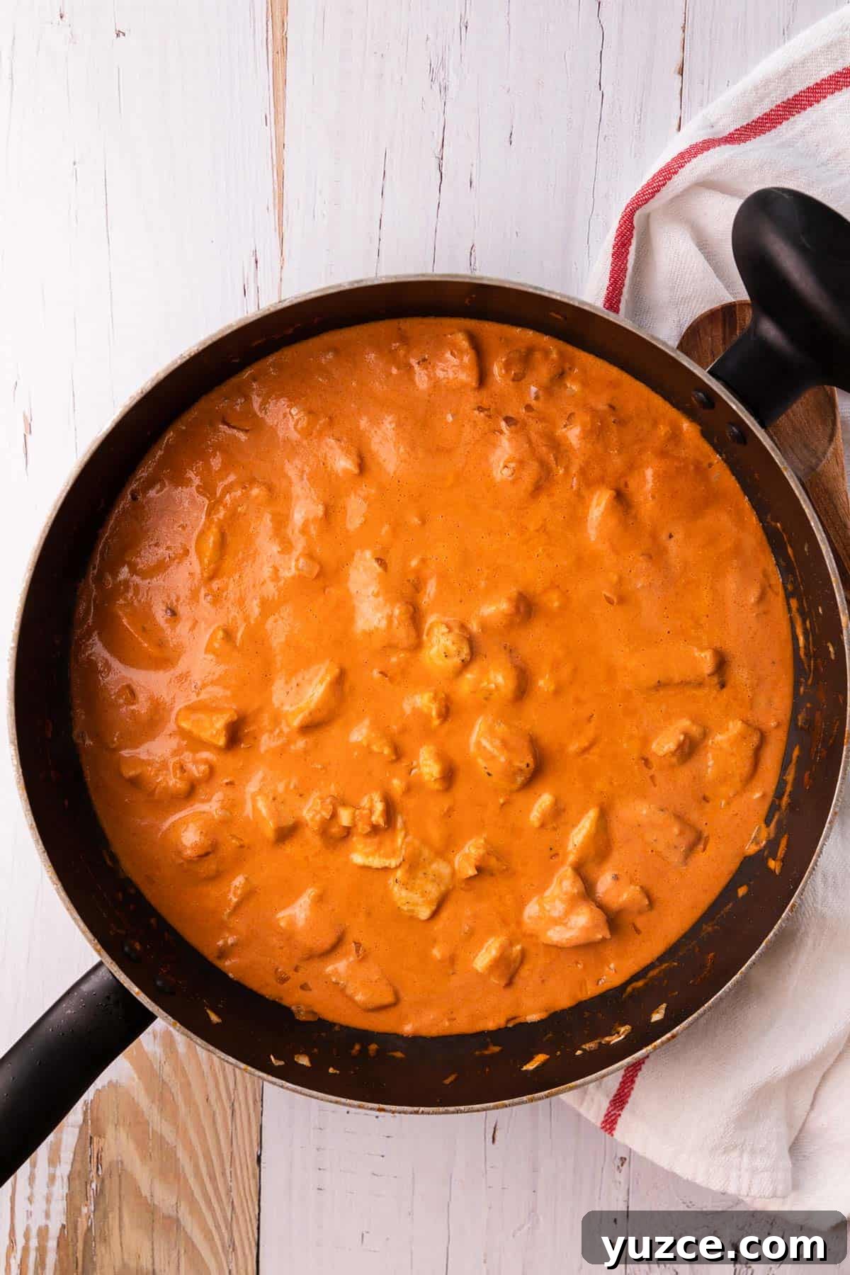 a skillet with cooked chicken in a tomato sauce