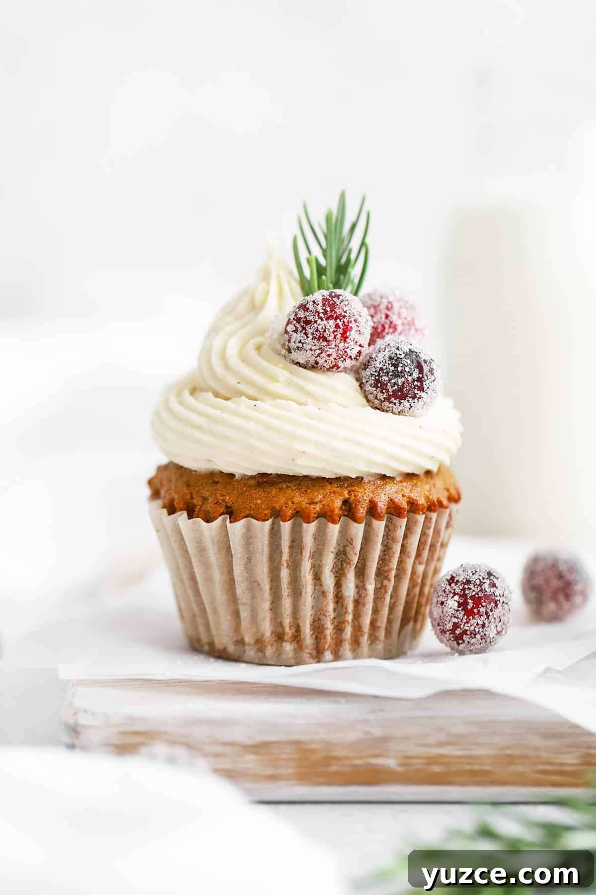 Sugared Cranberries Recipe: Simple Steps for Sparkling Cranberry Garnish 11 Front view of a gluten-free gingerbread cupcake topped with cream cheese, sugared cranberries, and rosemary
