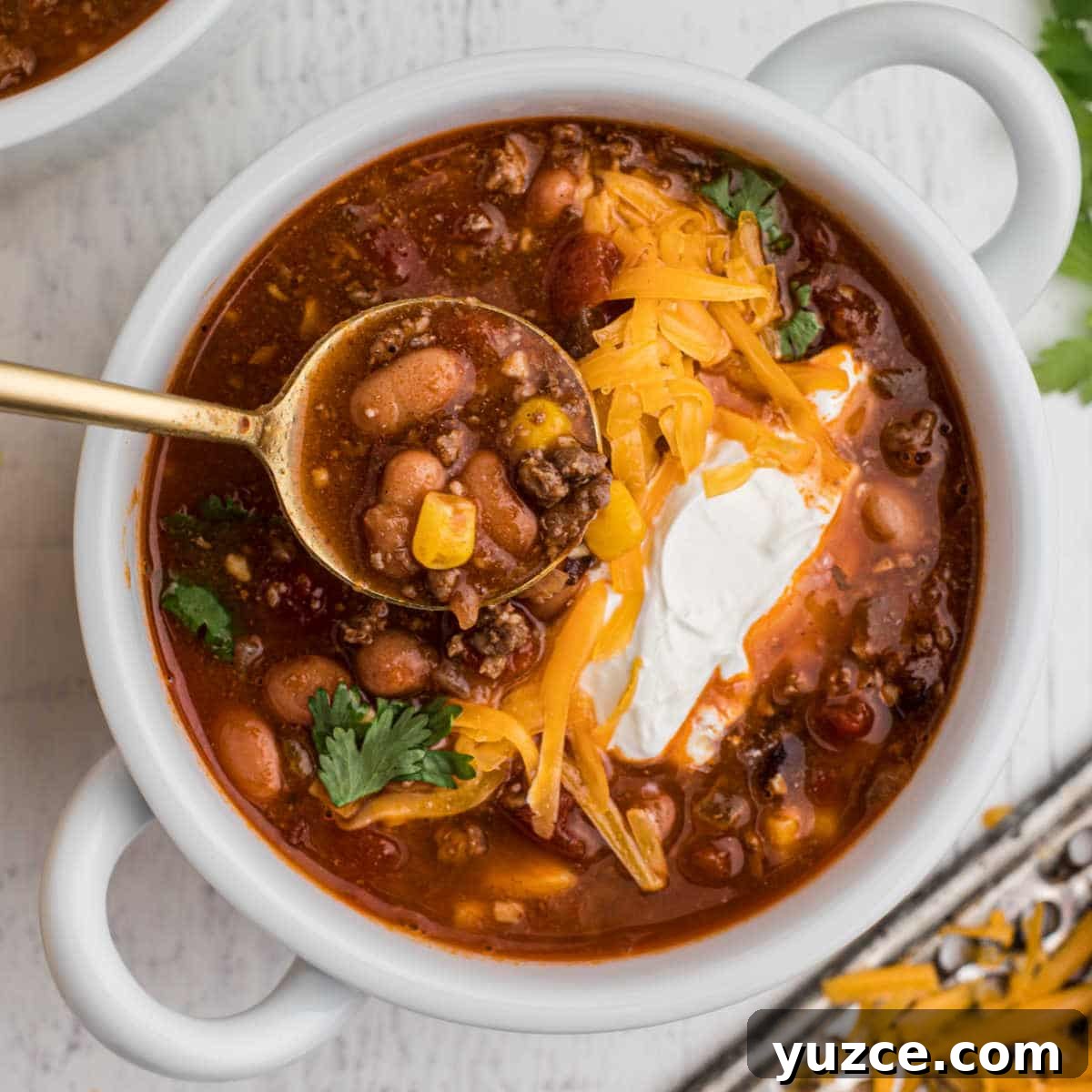 Hearty Dutch Oven Soup Recipes for Cozy Meals 11 bowl of taco soup with grated cheese and sour cream with a spoon digging in