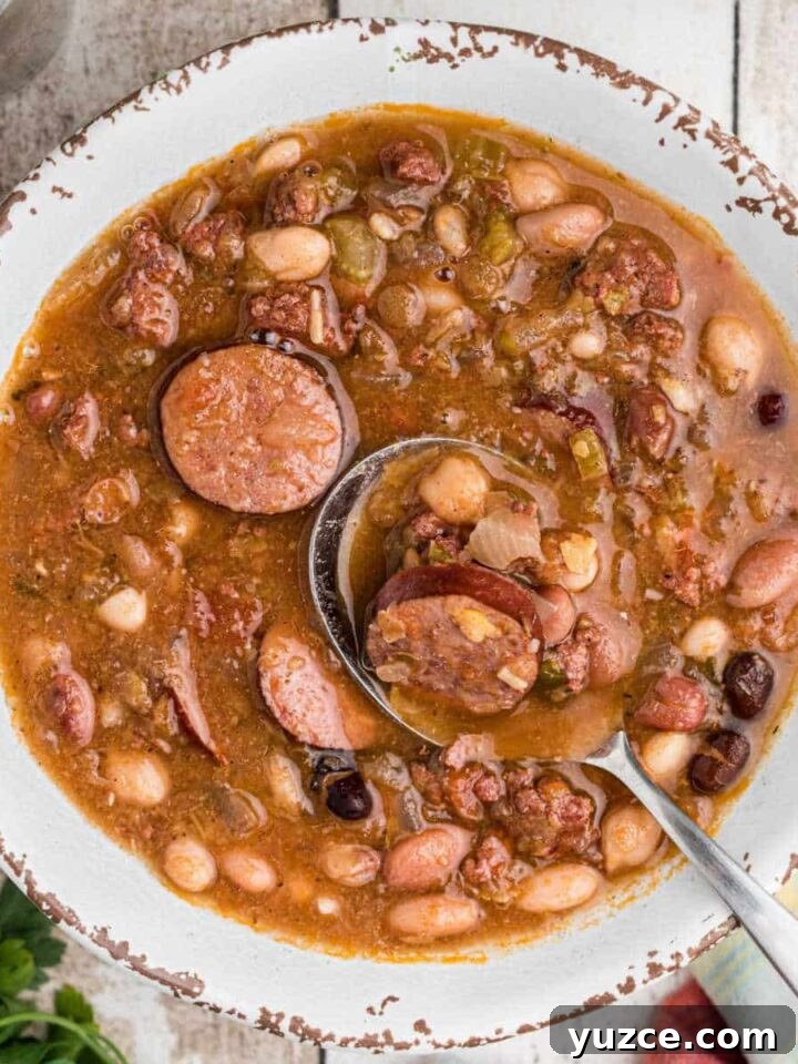 Hearty Dutch Oven Soup Recipes for Cozy Meals 18 overhead shot of a bowl of Cajun 15 bean soup with a spoon digging in.