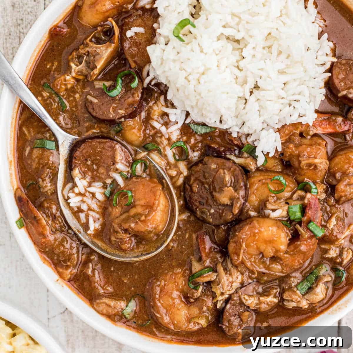 Hearty Dutch Oven Soup Recipes for Cozy Meals 6 Close up of a bowl of seafood gumbo with a pile of rice and a spoon digging into it.