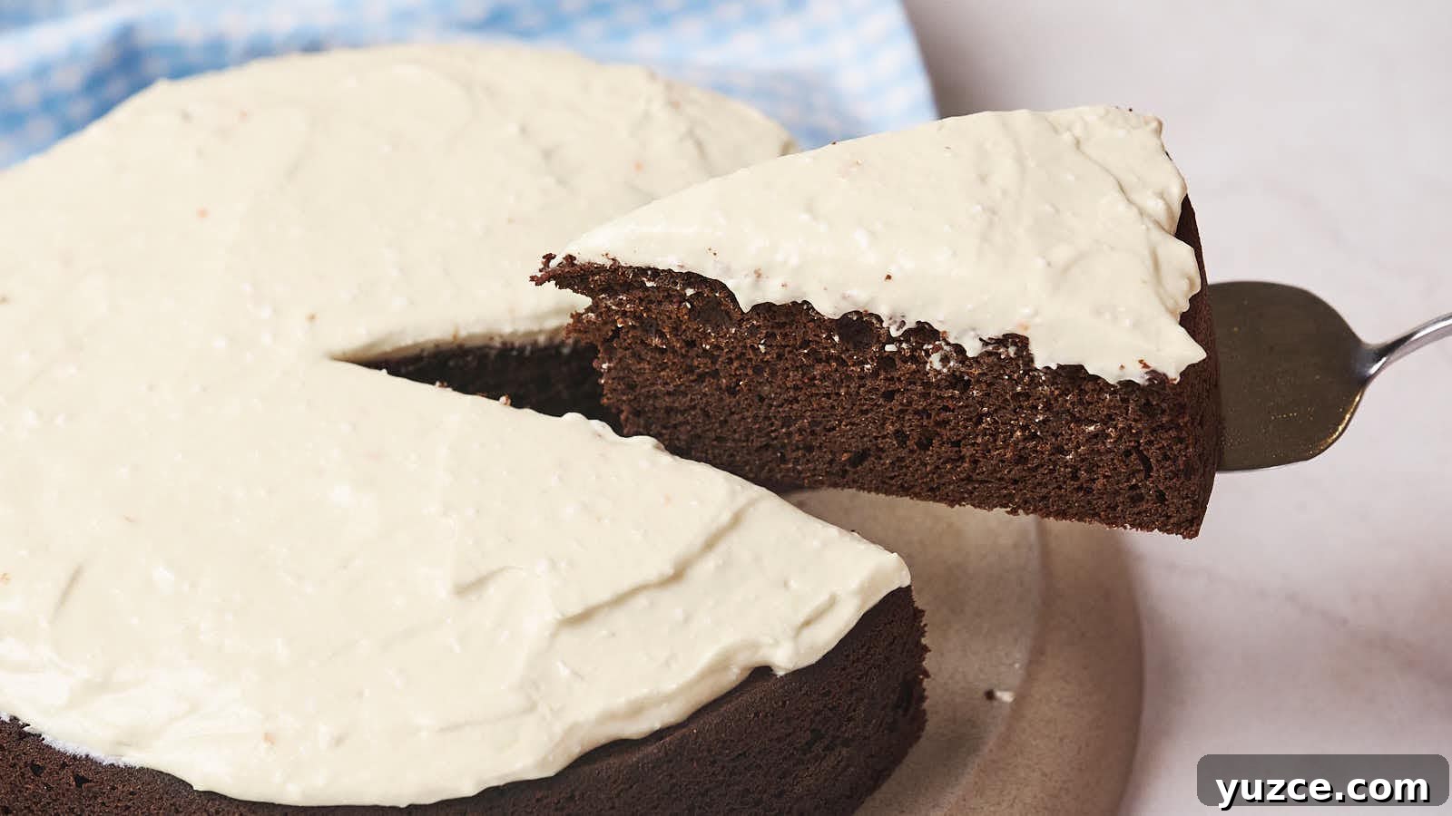 13 Sugar-Free Christmas Sweets That Still Feel Decadent 6 A slice of chocolate cake with white frosting being lifted from the whole cake.
