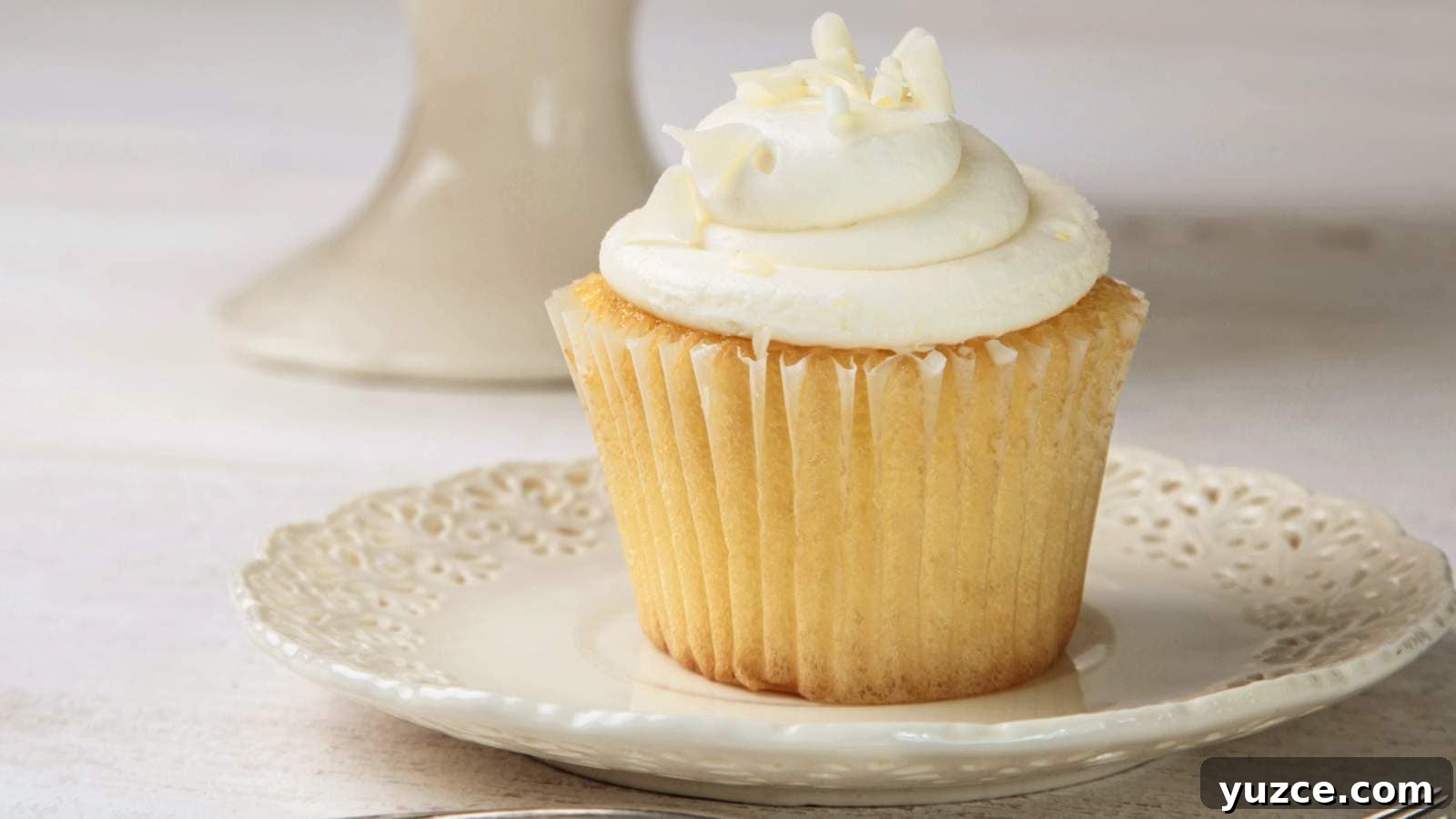 13 Sugar-Free Christmas Sweets That Still Feel Decadent 8 Vanilla cupcake with frosting on white china plate.