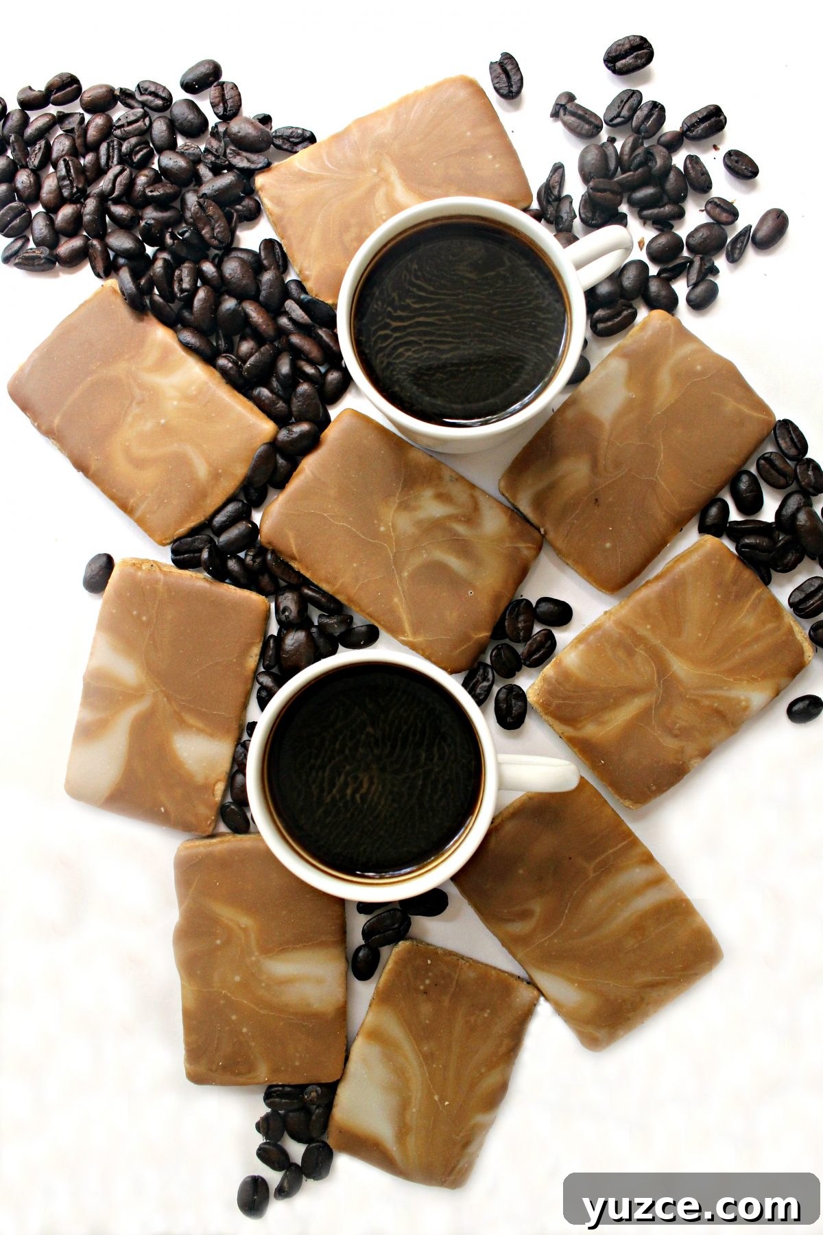 Crispy Coffee Cookies Recipe for Rich, Homemade Flavor 2 Thin, rectangular Coffee Cookies topped with brown and white marbled icing, surrounded by coffee beans.