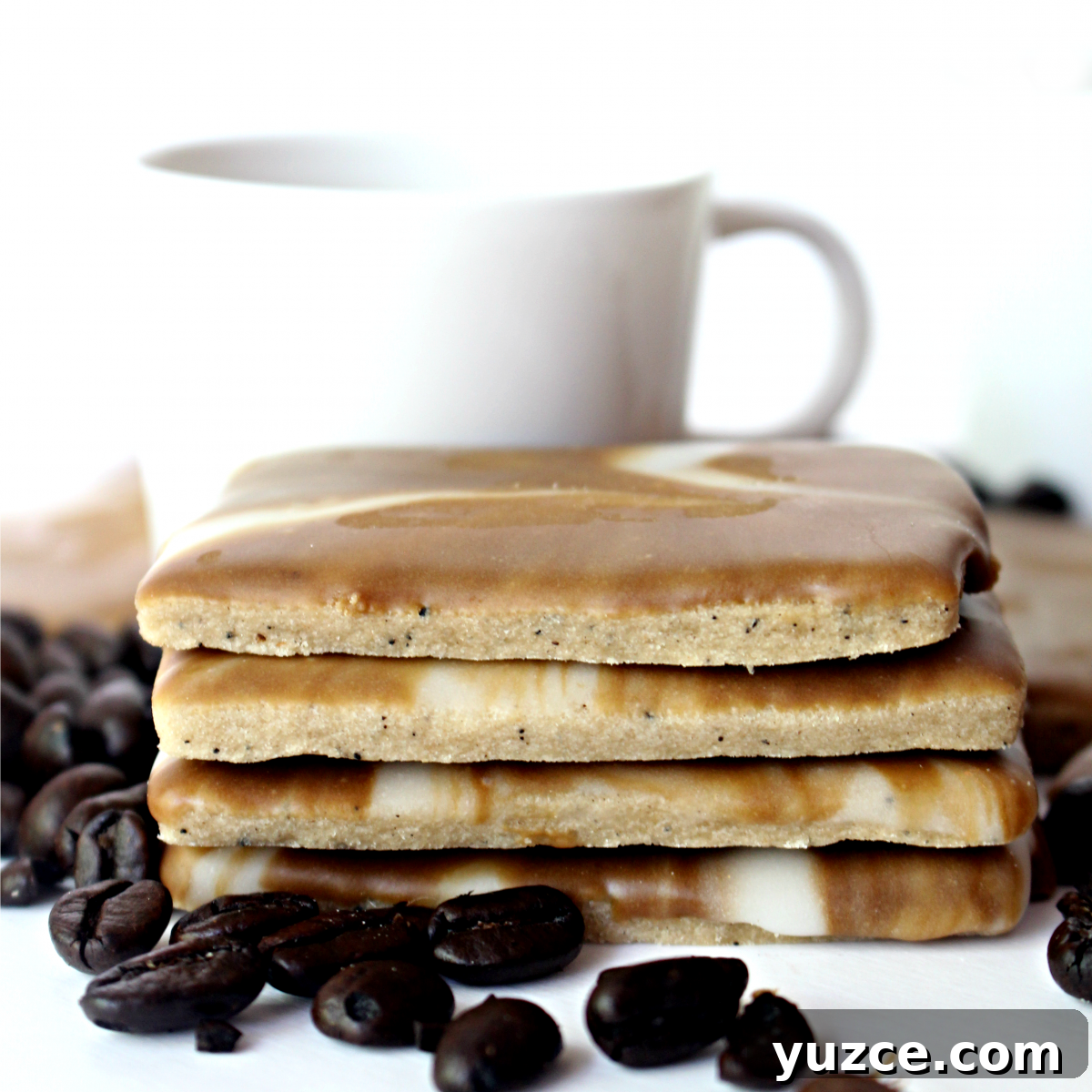 Crispy Coffee Cookies Recipe for Rich, Homemade Flavor 3 Stack of cookies showing thin, coffee speckled cookies topped with firmed icing.