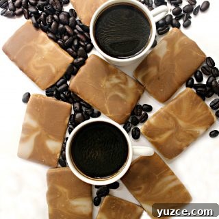 Coffee Cookies with brown and white marbled icing on a white background with coffee beans and 2 white mugs of espresso