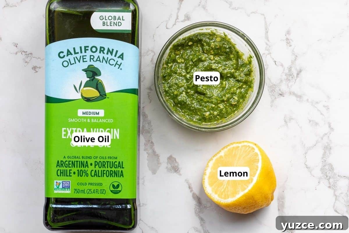 Creamy Pesto Salad Dressing Recipe for Fresh Greens 3 bottle of olive oil, bowl of pesto, and half a lemon.