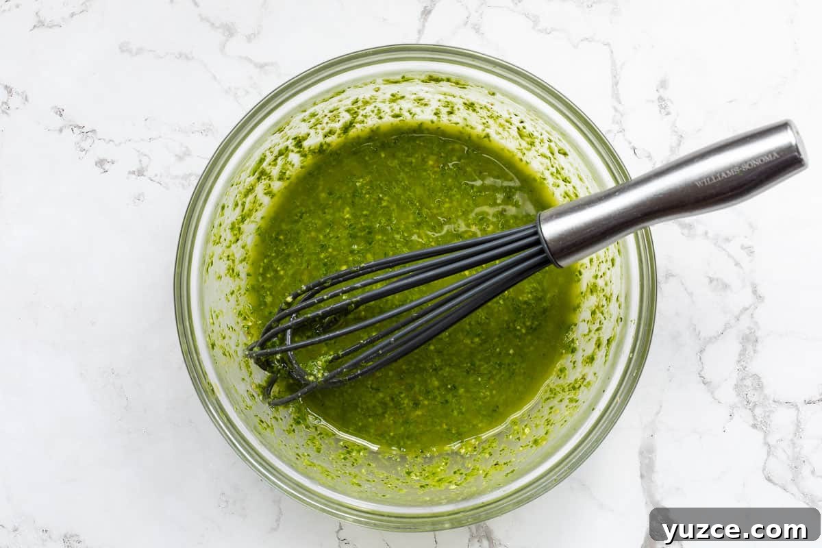 Creamy Pesto Salad Dressing Recipe for Fresh Greens 4 glass bowl with pesto salad dressing and whisk.